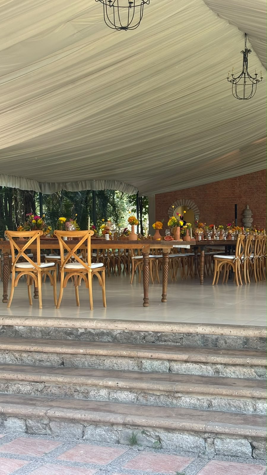 Montaje bajo carpa con sillas crossback y candelabros colgantes